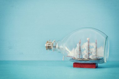 Deniz kavramı görüntü yelkende şişe mavi ahşap masa ve arka plan ile. Seçici odak.
