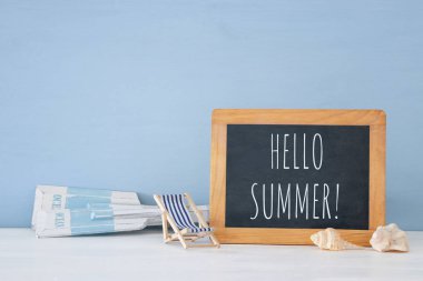 ahşap dekoratif tekne kürek, plaj sandalyesini, deniz kabukları ve yazı tahtası üzerinde mavi arka plan ile deniz kavramı.