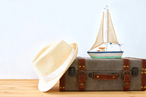 Equipaje vintage viajero, barco y sombrero fedora sobre mesa de madera. vacaciones y concepto de vacaciones . —  Fotos de Stock