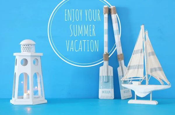 Морская концепция с белым декоративным фонарем маяка, деревянными веслами и лодкой на синем фоне . — стоковое фото