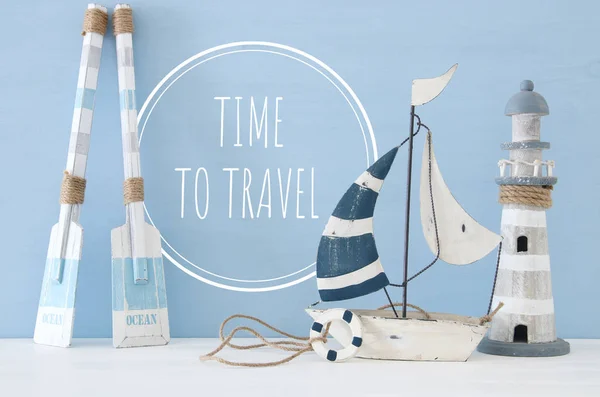 Морское концептуальное изображение с декоративными веслами, лодкой и маяком на светло-голубом фоне . — стоковое фото
