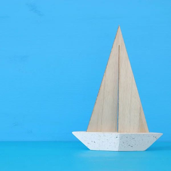 Conceito náutico com barco de vela decorativo branco sobre mesa de madeira azul e fundo . — Fotografia de Stock