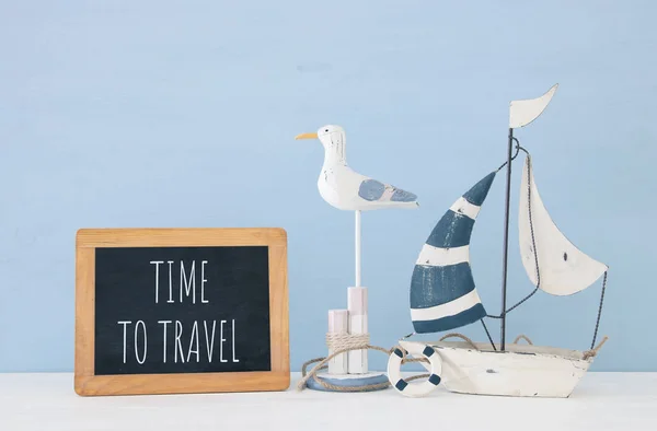 Nautisches Konzept mit weißem dekorativen Möwenvogel, Tafel und Boot über blauem Holzgrund. — Stockfoto