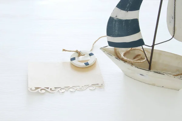Námořních koncept obrázek s bílé dekorační plachetnice a poznámku nad bílý dřevěný stůl. — Stock fotografie