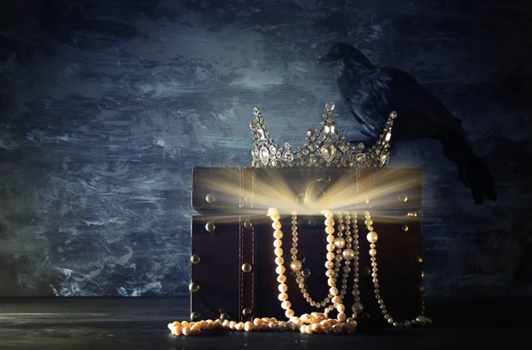 Imagen de la llave baja de la hermosa corona reina / rey y cuervo negro. época medieval de fantasía. Enfoque selectivo . — Foto de Stock