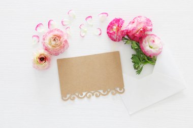 Zarf ile hassas pastel pembe güzel çiçek aranjman beyaz ahşap zemin üzerinde görüntü. Düz yatıyordu, en iyi görünümü.