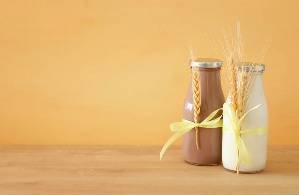 Bild von Milch und Schokolade mit Weizen über Holztisch und Pastell Hintergrund. Symbole des jüdischen Feiertags - shavuot. — Stockfoto