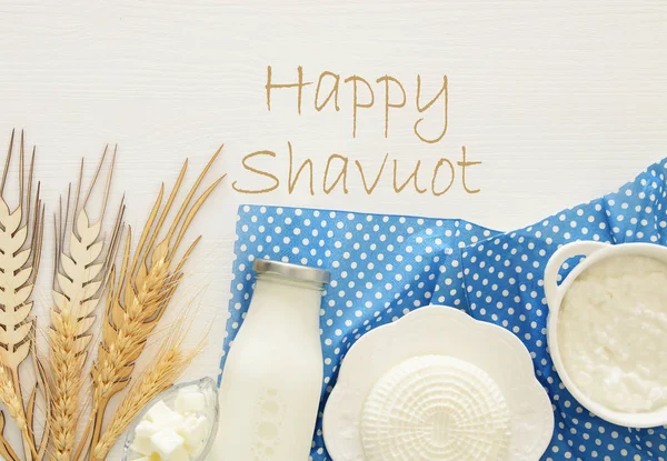 Bild von oben mit Milchprodukten auf mintfarbenem Holzgrund. Symbole des jüdischen Feiertags - shavuot. — Stockfoto