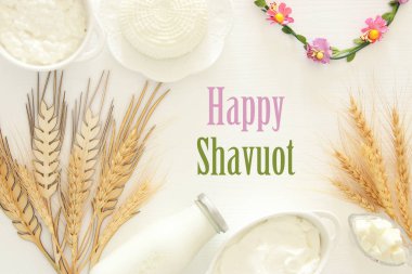 Beyaz ahşap zemin üzerinde süt ürünleri üstten görünüm görüntüsü. Sembolleri Yahudi tatil - Shavuot.