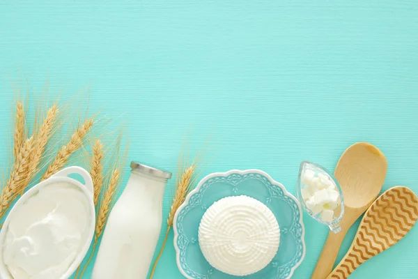 Vista dall'alto immagine di prodotti lattiero-caseari su sfondo di legno menta. Simboli di vacanza ebrea - Shavuot . — Foto Stock