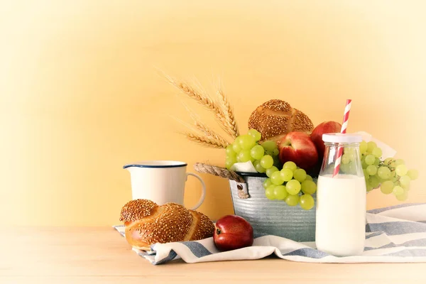 Imagem de frutas, pão e queijo na cesta de lata sobre mesa de madeira . — Fotografia de Stock
