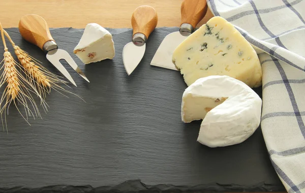 image of dairy products over black stone slate background. Symbols of jewish holiday - Shavuot.