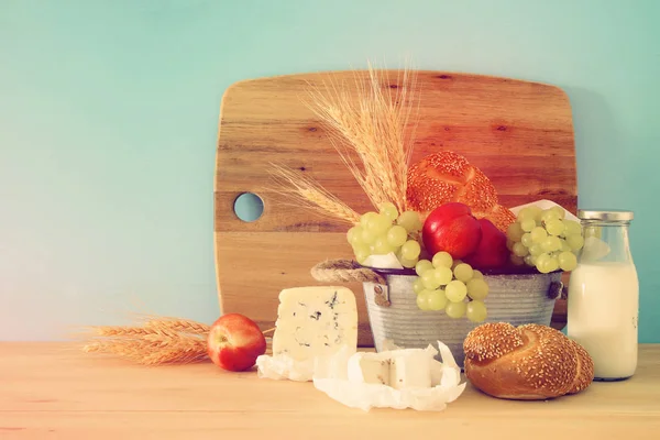 Imagem de frutas, pão e queijo na cesta de lata sobre mesa de madeira . — Fotografia de Stock