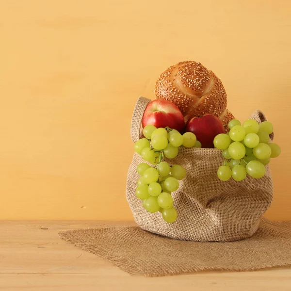 Image of fruits and bread in the basket over wooden table. — Stock Photo, Image