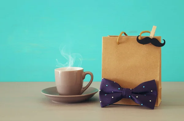 Imagen de bolsa de compras, pajarita y taza de café, regalo para papá. Concepto del día del padre . — Foto de Stock