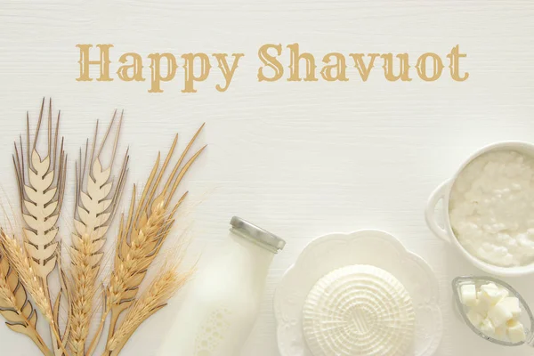 白い木製の背景に乳製品のトップ ビュー イメージ。ユダヤ人の休日 - シャブオットのシンボル. — ストック写真
