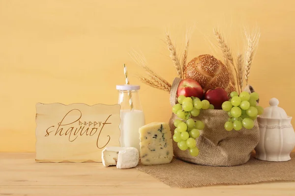 Image of fruits, bread and cheese in the basket over wooden table. — Stock Photo, Image