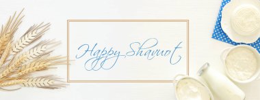 Beyaz ahşap zemin üzerinde süt ürünleri üstten görünüm görüntüsü. Sembolleri Yahudi tatil - Shavuot.