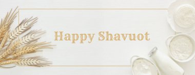 Beyaz ahşap zemin üzerinde süt ürünleri üstten görünüm görüntüsü. Sembolleri Yahudi tatil - Shavuot.