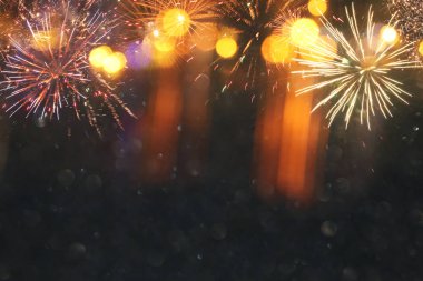 Havai fişeklerle soyut siyah ve altın parıltılı arka plan. Noel arifesi, 4 Temmuz bayramı konsepti..