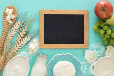 Beyaz ahşap zemin üzerinde süt ürünleri üstten görünüm görüntüsü. Sembolleri Yahudi tatil - Shavuot.