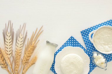 Beyaz ahşap zemin üzerinde süt ürünleri üstten görünüm görüntüsü. Sembolleri Yahudi tatil - Shavuot.