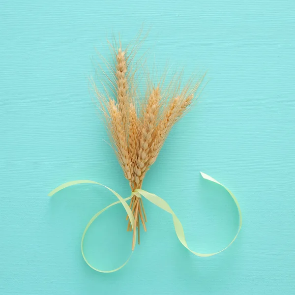 Ansicht der Holzdekoration der Weizenernte über pastellfarbenem Holzhintergrund. Symbole des jüdischen Feiertags - shavuot. — Stockfoto