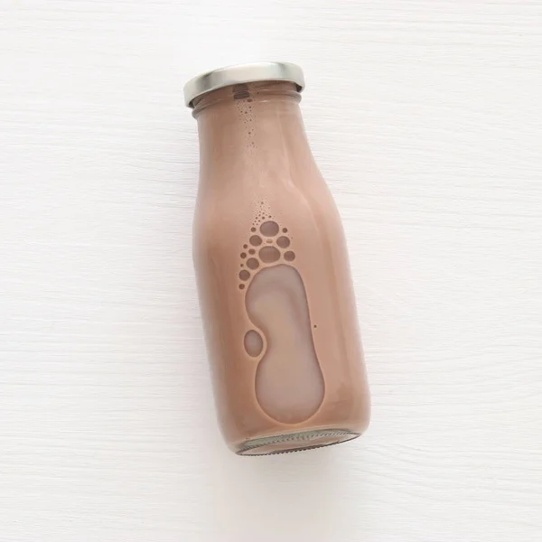 Top view image of chocolate milk over white wooden background. Symbols of jewish holiday - Shavuot. — Stock Photo, Image