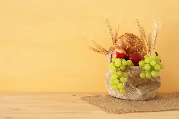 Imagen de frutas y pan en la cesta sobre mesa de madera . —  Fotos de Stock