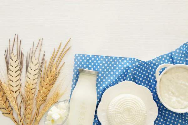 Bild von oben mit Milchprodukten auf weißem Holzhintergrund. Symbole des jüdischen Feiertags - shavuot. — Stockfoto