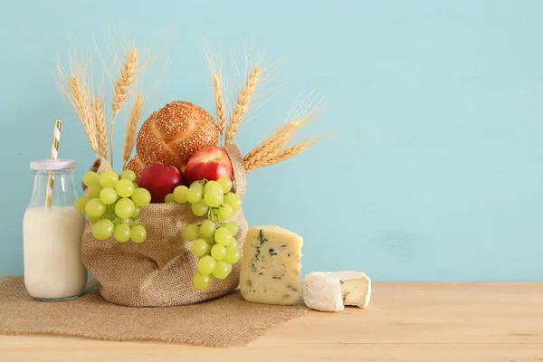 Bild von Früchten, Brot und Käse im Korb über Holztisch. — Stockfoto
