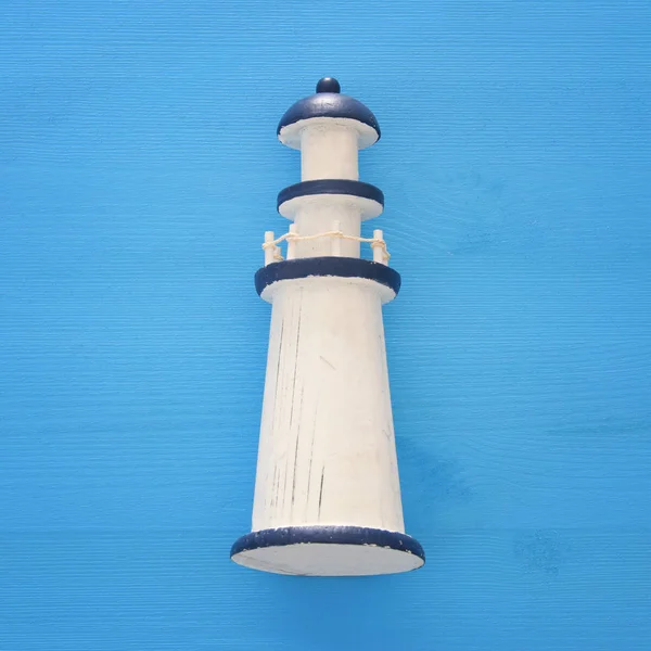 Vacation and summer image with lighthouse over blue wooden background. — Stock Photo, Image