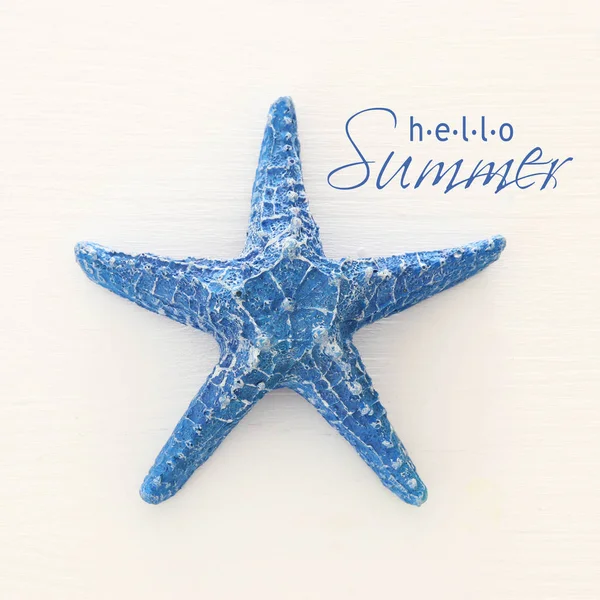 Férias e imagem de verão com estrela do mar sobre fundo de madeira branco . — Fotografia de Stock