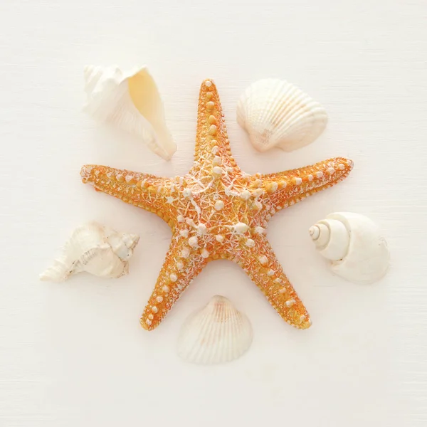 Отдых и летнее изображение с морской звездой и ракушками на белом деревянном фоне . — стоковое фото