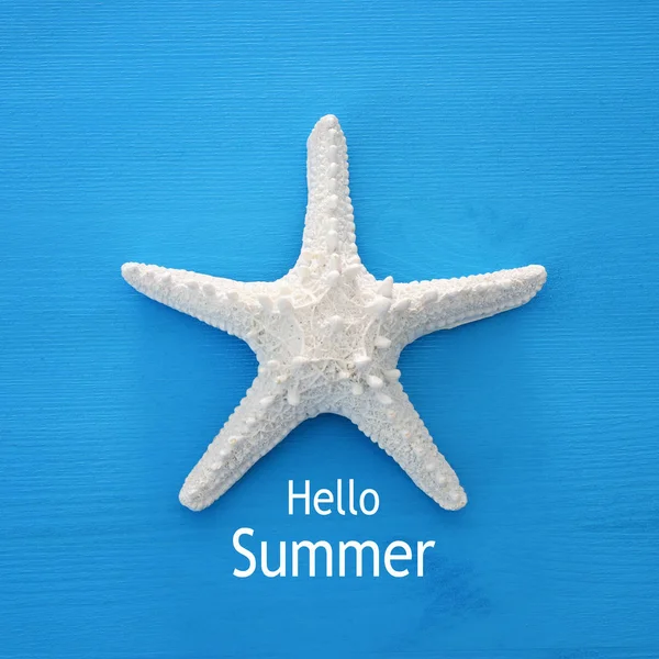 Férias e imagem de verão com estrela do mar sobre fundo de madeira azul . — Fotografia de Stock