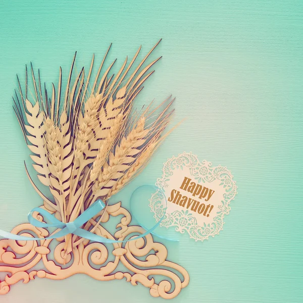 Top view of wooden wheat crop decoration over mint background. Symbols of jewish holiday - Shavuot. — Stock Photo, Image
