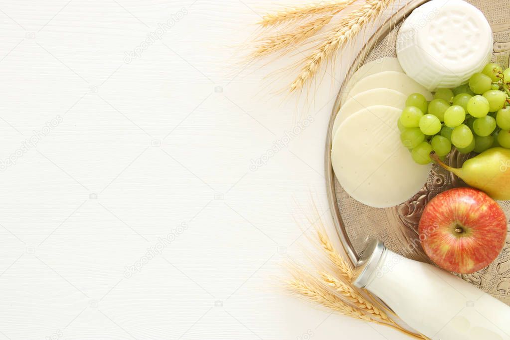Top view image of dairy products over white wooden background. Symbols of jewish holiday - Shavuot