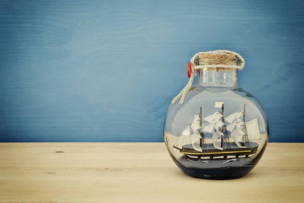Concepto náutico imagen con velero en botella sobre mesa de madera. Enfoque selectivo . —  Fotos de Stock