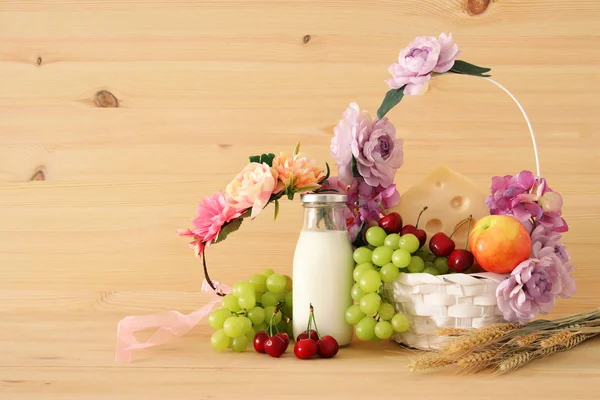 Зображення фруктів і сиру в декоративних кошик з квітами над дерев'яний стіл. Символи єврейське свято - Шавуот. — стокове фото