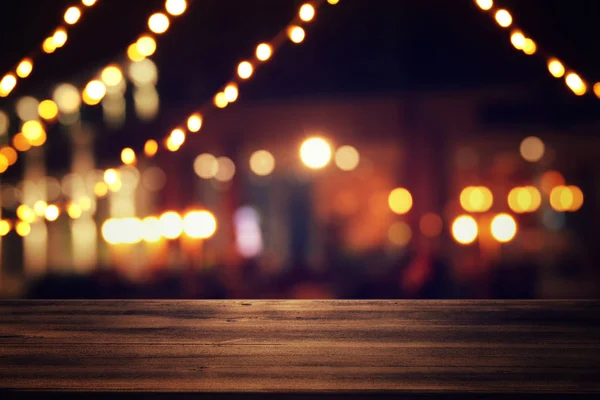 Obraz z drewnianym stole przed streszczenie niewyraźne restauracja świeci tło. — Zdjęcie stockowe