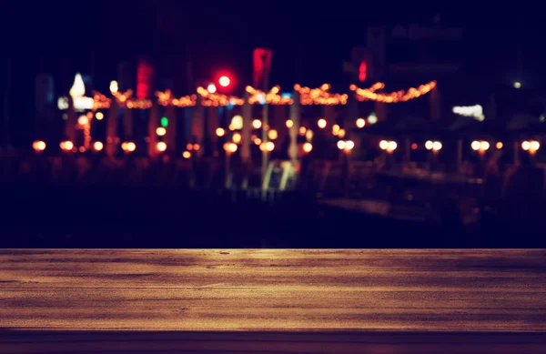 Obraz z drewnianym stole przed streszczenie niewyraźne restauracja świeci tło. — Zdjęcie stockowe