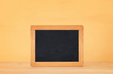 ahşap masa ve sarı pastel arka plan üzerinde kopya alanı için boş yazı tahtası ile deniz kavramı.