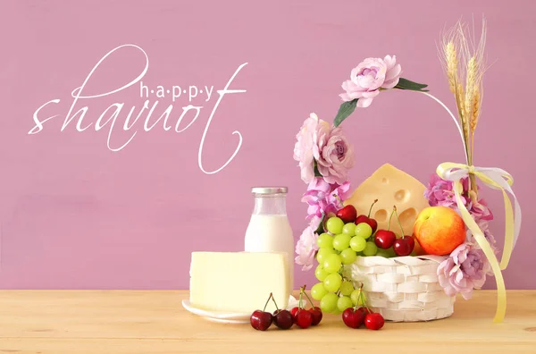 Εικόνα του φρούτα και τυρί σε διακοσμητικό καλάθι με λουλούδια πάνω από το ξύλινο τραπέζι. Σύμβολα της εβραϊκής διακοπές - Σαβότ. — Φωτογραφία Αρχείου