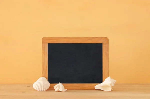 Morskie koncepcja z pusta tablica do miejsca kopiowania i muszle na drewnianym stole. — Zdjęcie stockowe