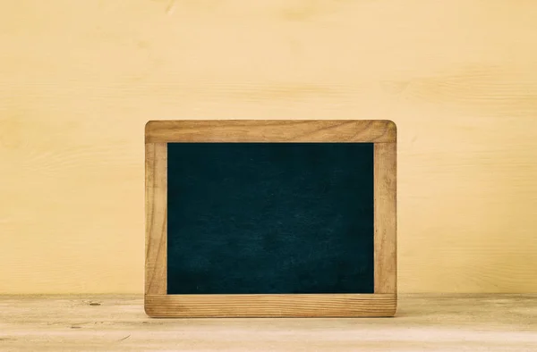 Nautiska koncept med tomma blackboard för kopia utrymme över träbord och gul pastell bakgrund. — Stockfoto