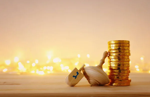 Conceito de religião de férias judaicas Hanukkah com dreidels de madeira (spinning top) e moedas de chocolate sobre mesa de madeira e bokeh luzes de fundo — Fotografia de Stock