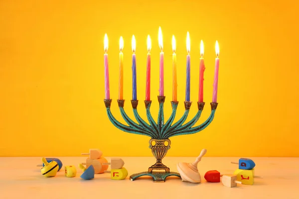 Imagen religiosa de vacaciones judías fondo Hanukkah con menorah (candelabro tradicional) y la tapa giratoria sobre fondo amarillo —  Fotos de Stock