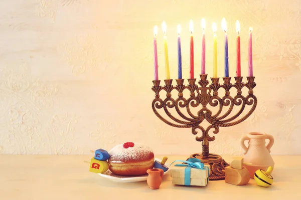 Θρησκευτική εικόνα της εβραϊκής διακοπές Hanukkah φόντο με μενόρα (παραδοσιακά κηροπήγια), περιστρεφόμενη κορυφή και ντόνατ — Φωτογραφία Αρχείου