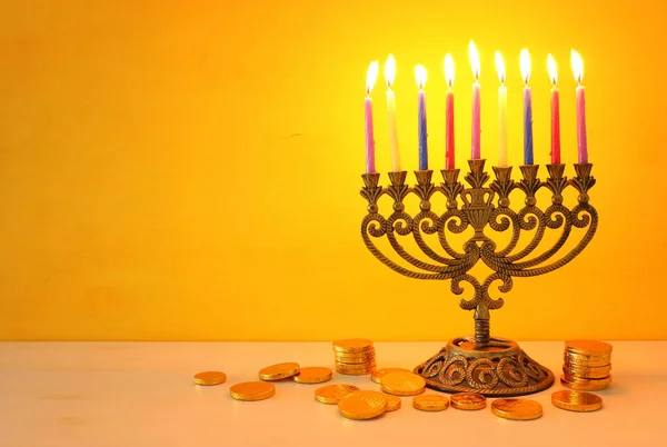 Imagen religiosa de vacaciones judías fondo Hanukkah con menorah (candelabro tradicional) y la tapa giratoria sobre fondo amarillo —  Fotos de Stock