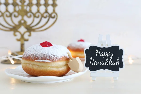 Religión imagen de vacaciones judías fondo Hanukkah con tapa giratoria y rosquilla sobre fondo blanco —  Fotos de Stock